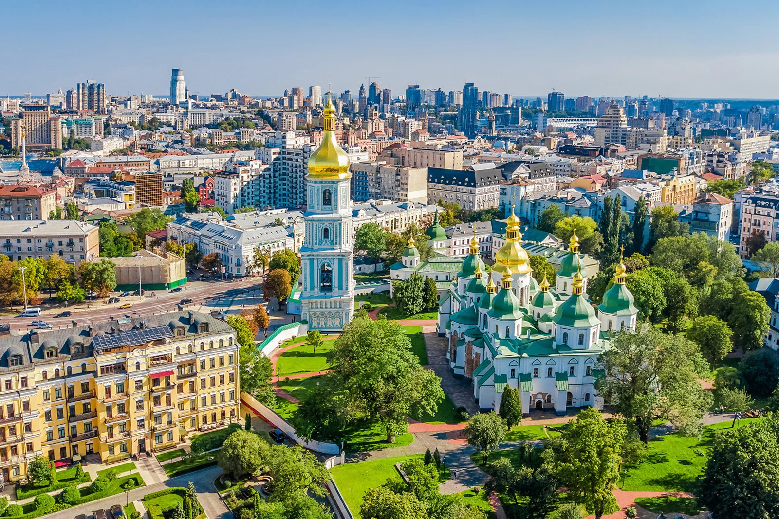 Aerial view of a golden-domed cathedral complex surrounded by a dense European capital
