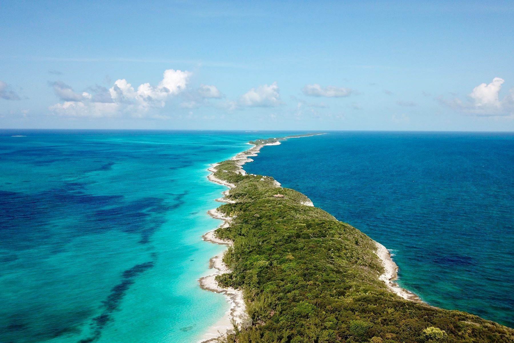 Aerial view of a long narrow wooded island ridge dividing deep blue and turquoise water
