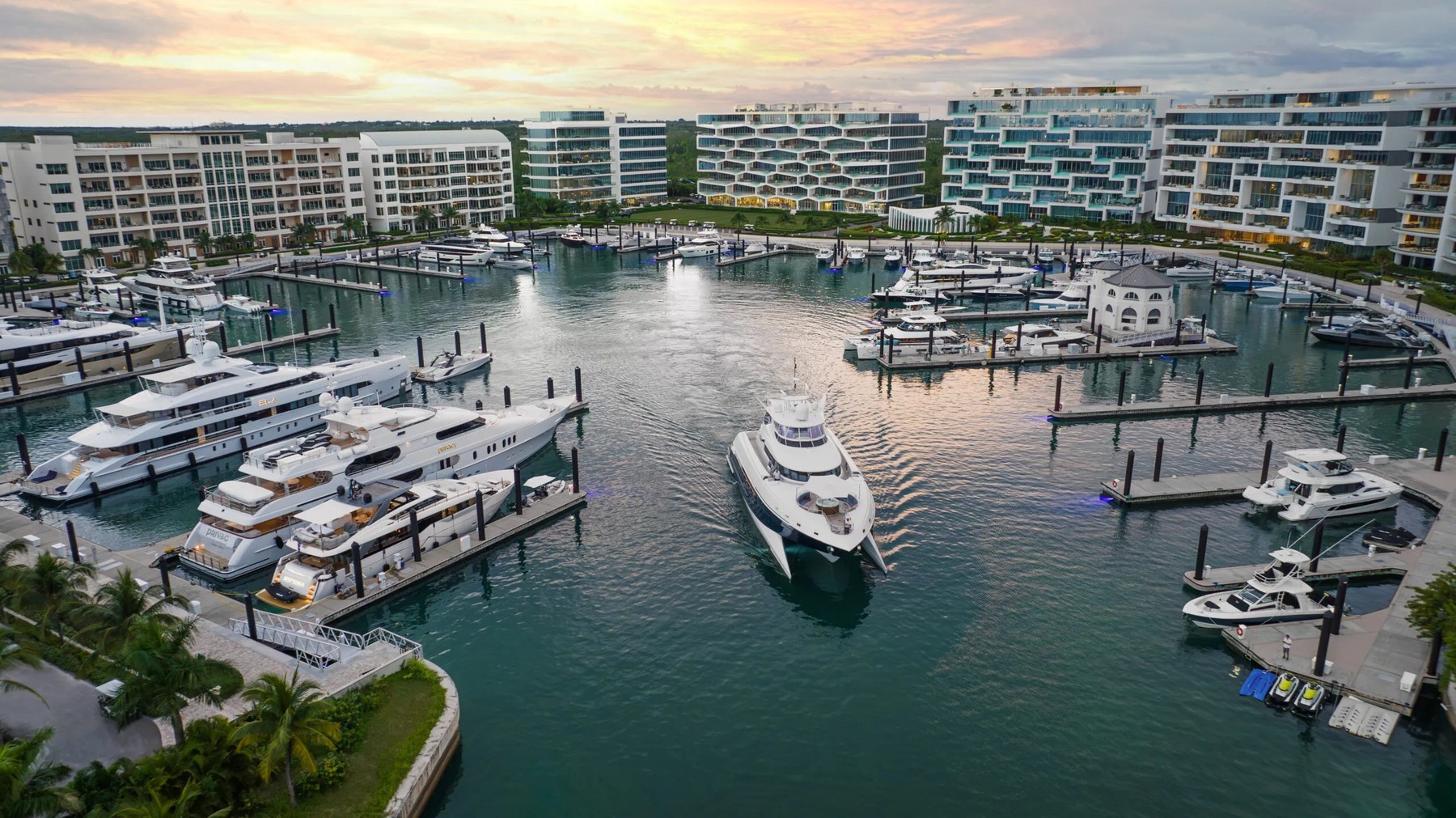 Superyachts moored at sunset in the Albany marina basin, ringed by the community's residential buildings, New Providence, the Bahamas