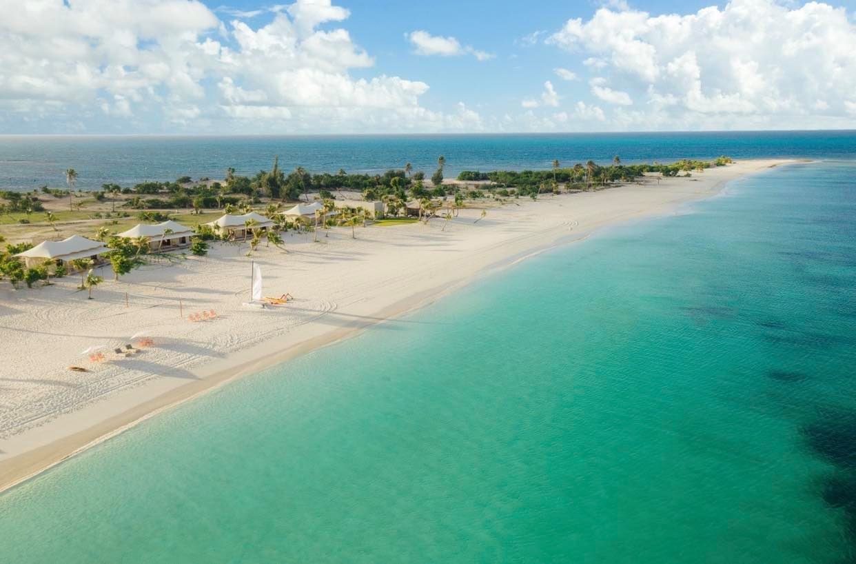 Aerial view of Barbuda Ocean Club beach cottages lining a turquoise Barbuda shoreline