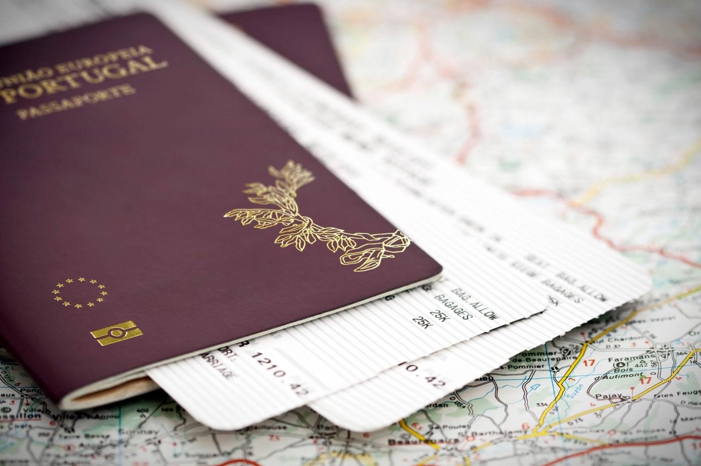 A burgundy passport and two boarding passes resting on a folded road map
