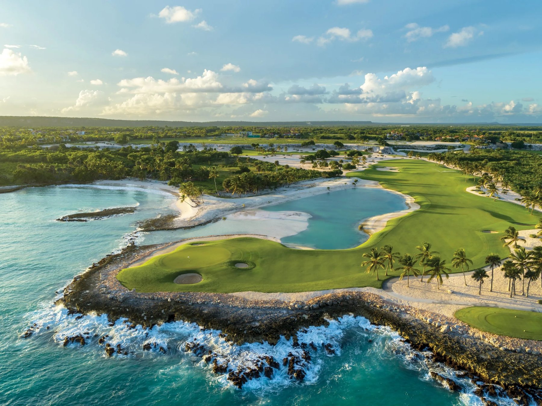 Golden-hour aerial of Punta Espada golf course meeting the Caribbean at Cap Cana