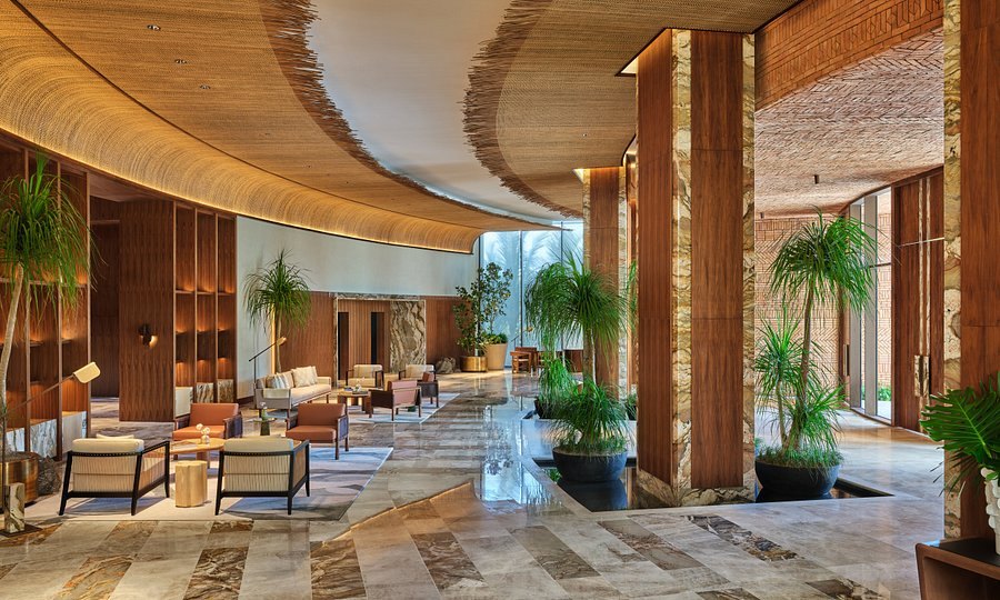 Open-air lobby with woven ceiling, travellers palms and travertine floors at St Regis Cap Cana