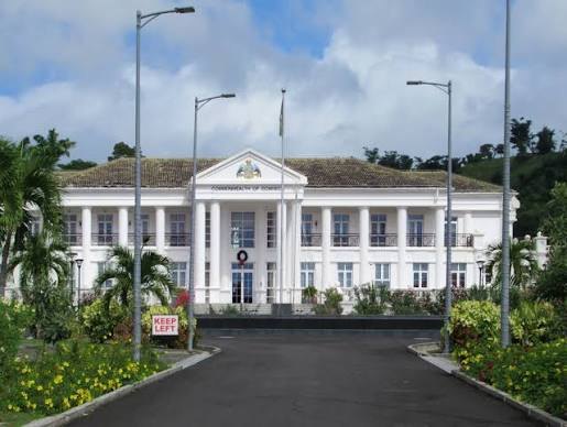 White neoclassical government headquarters of the Commonwealth of Dominica at the end of an empty drive