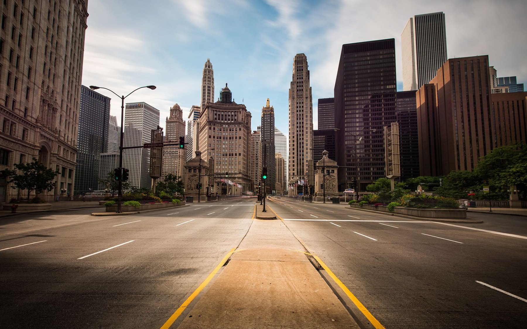 Empty multi-lane boulevard flanked by historic skyscrapers under soft morning light