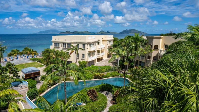 Hamilton Beach Villas buildings above the lagoon pool, Pinney's Beach and St Kitts beyond