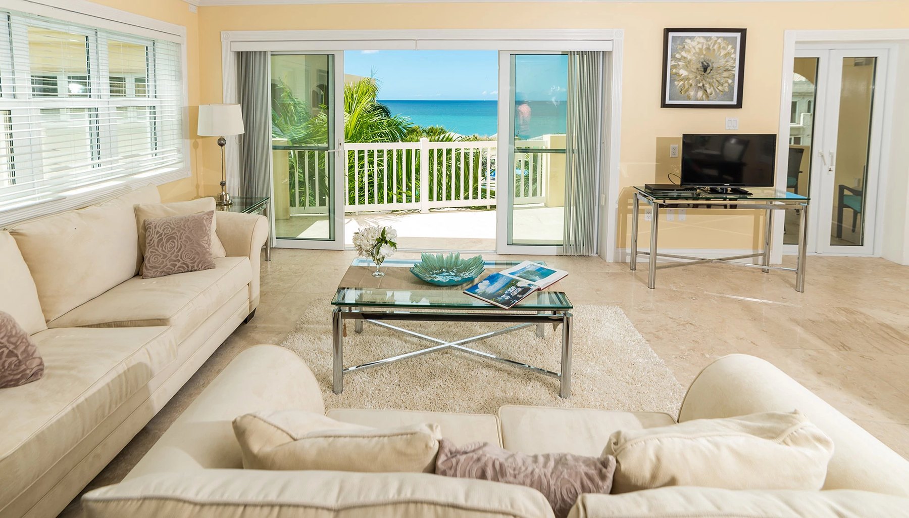 Living room at Hamilton Beach Villas with sliding doors opening to a sea-view balcony