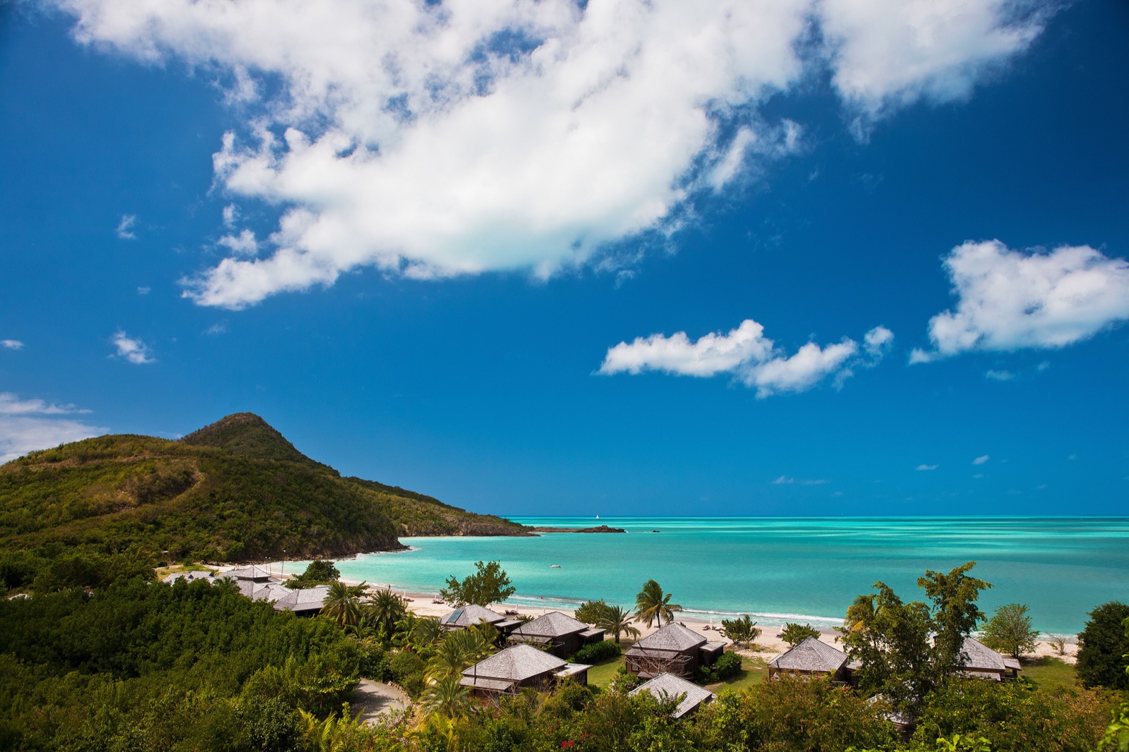 Aerial view of Hermitage Bay's hillside cottages, pool and white-sand beach, Antigua