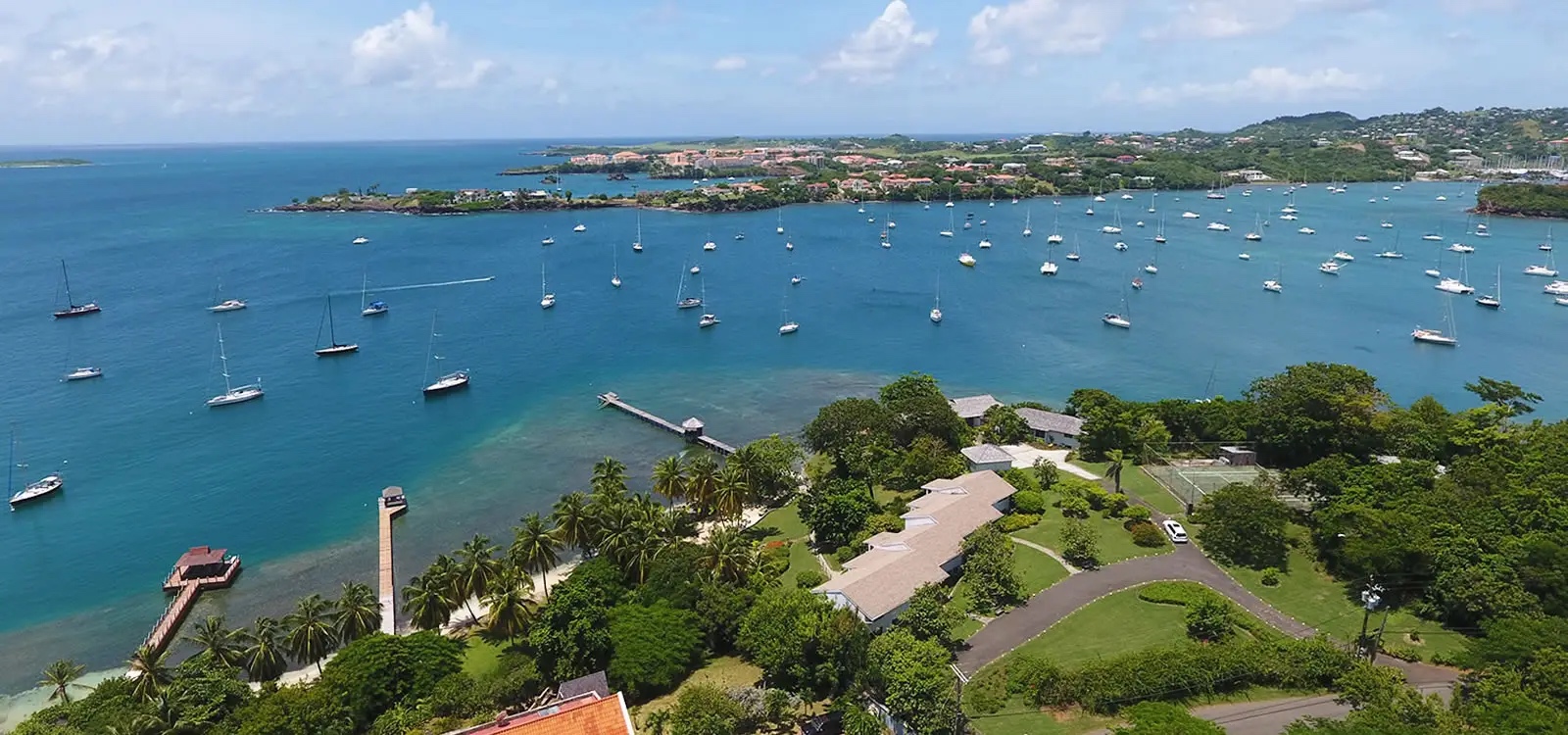 Aerial view of One True Blue rising on the headland above True Blue Bay, Grenada