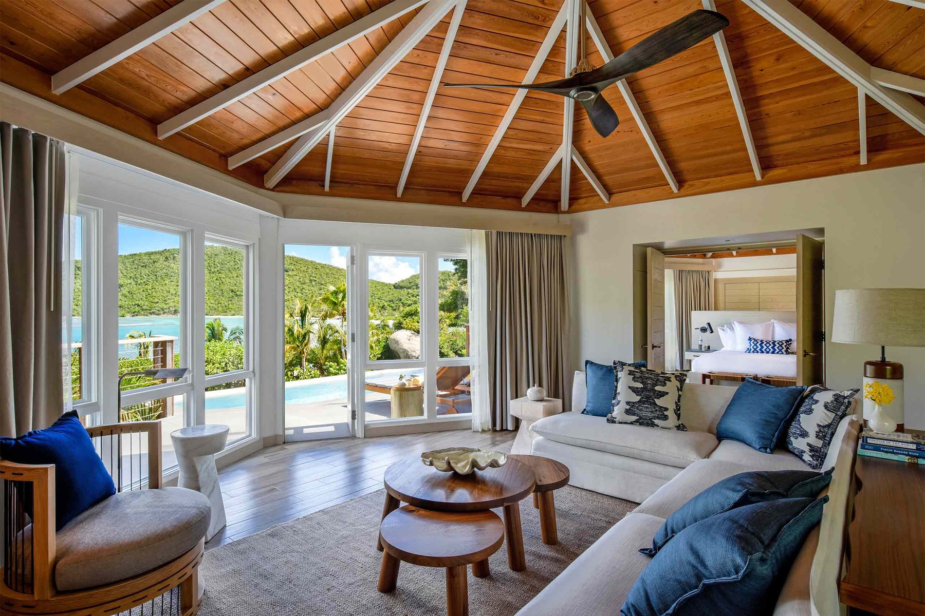Suite living room at Rosewood Little Dix Bay with vaulted wood ceiling and pool view