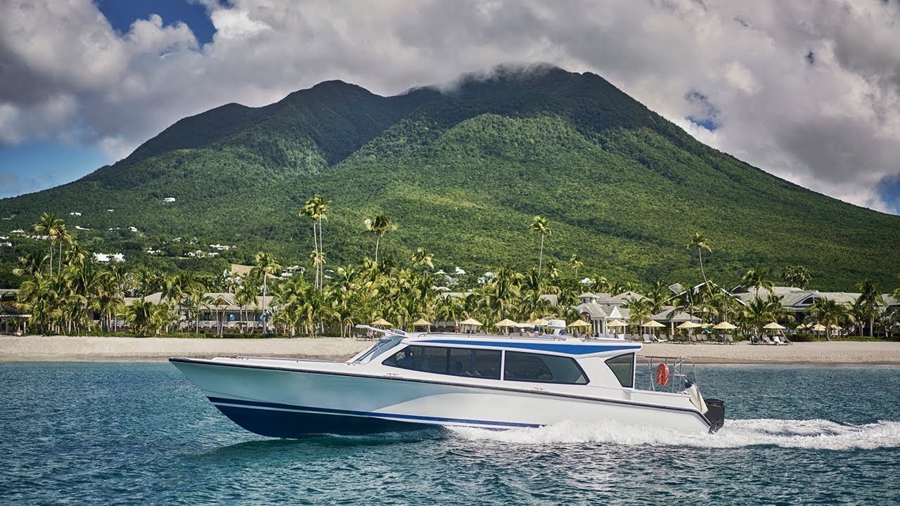 A resort water taxi running along the Nevis shoreline in front of the Four Seasons, Nevis Peak behind