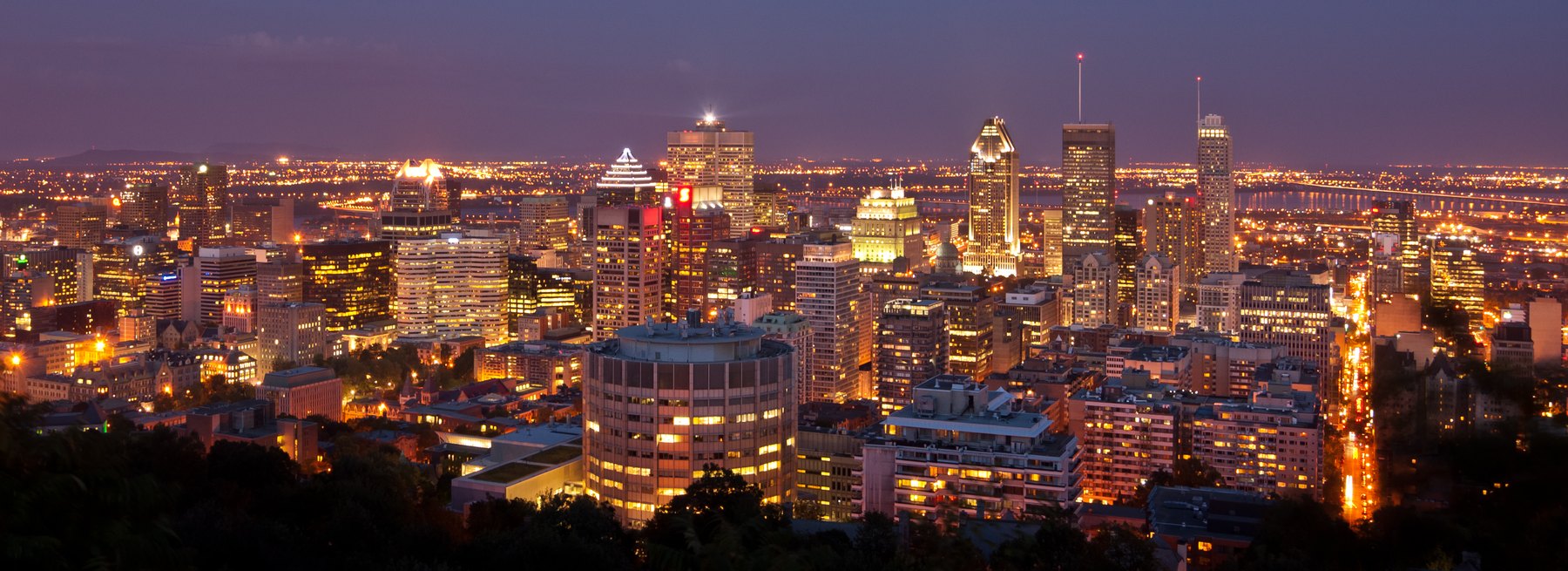 Montreal downtown office towers glowing at twilight above lit city streets