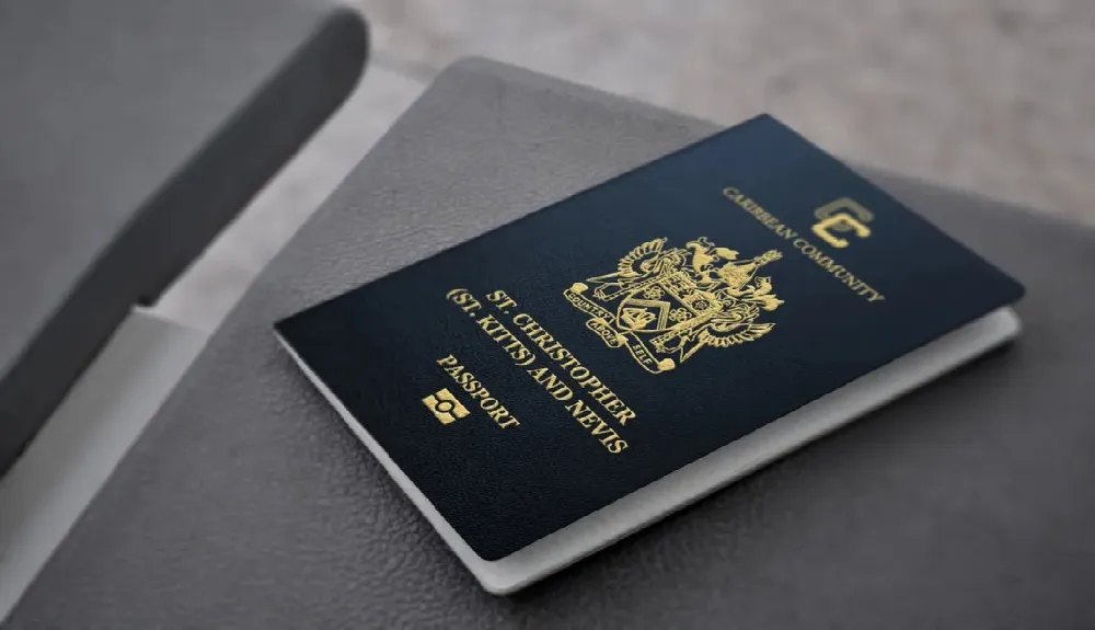 A Caribbean Community passport issued by St. Christopher (St. Kitts) and Nevis resting on a dark leather notebook