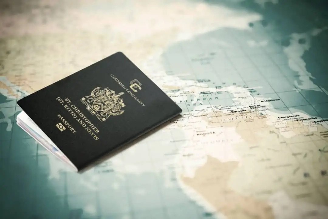 Navy Caribbean Community passport lying on a faded printed map, warm muted tones