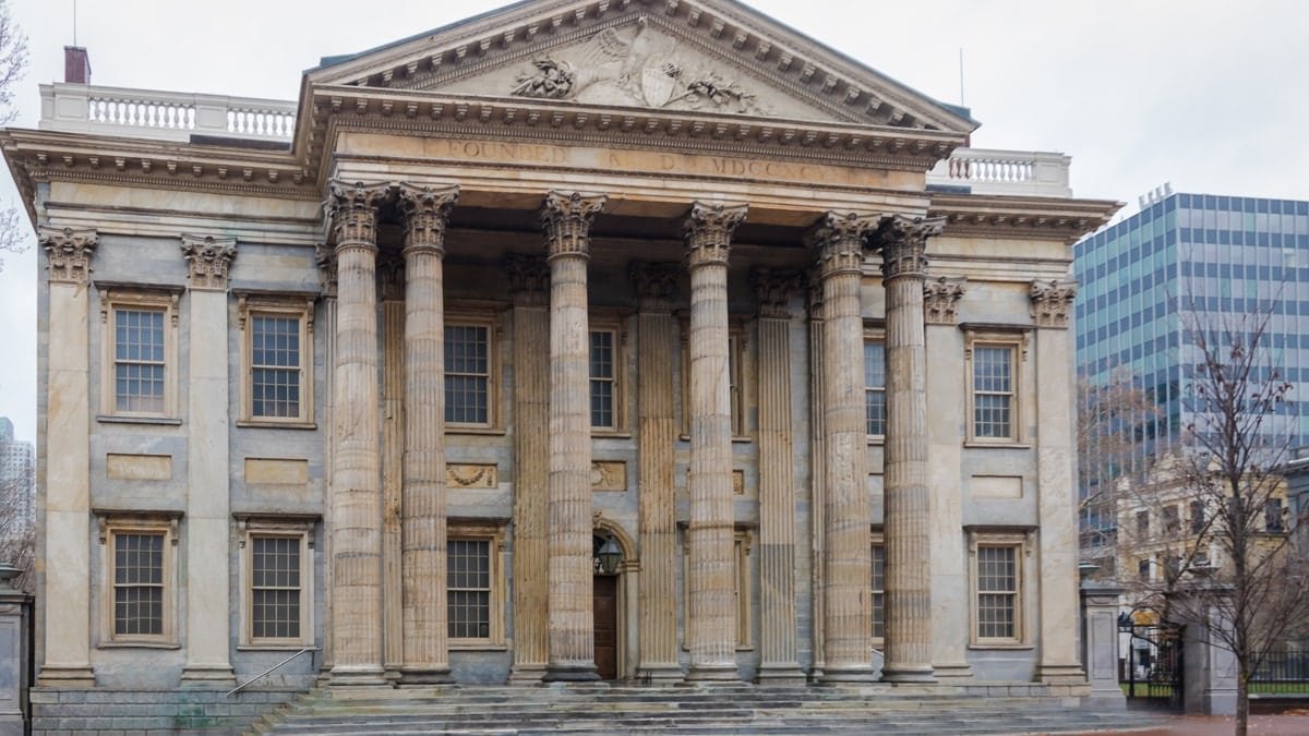 Neoclassical bank building with tall marble columns and a carved stone pediment