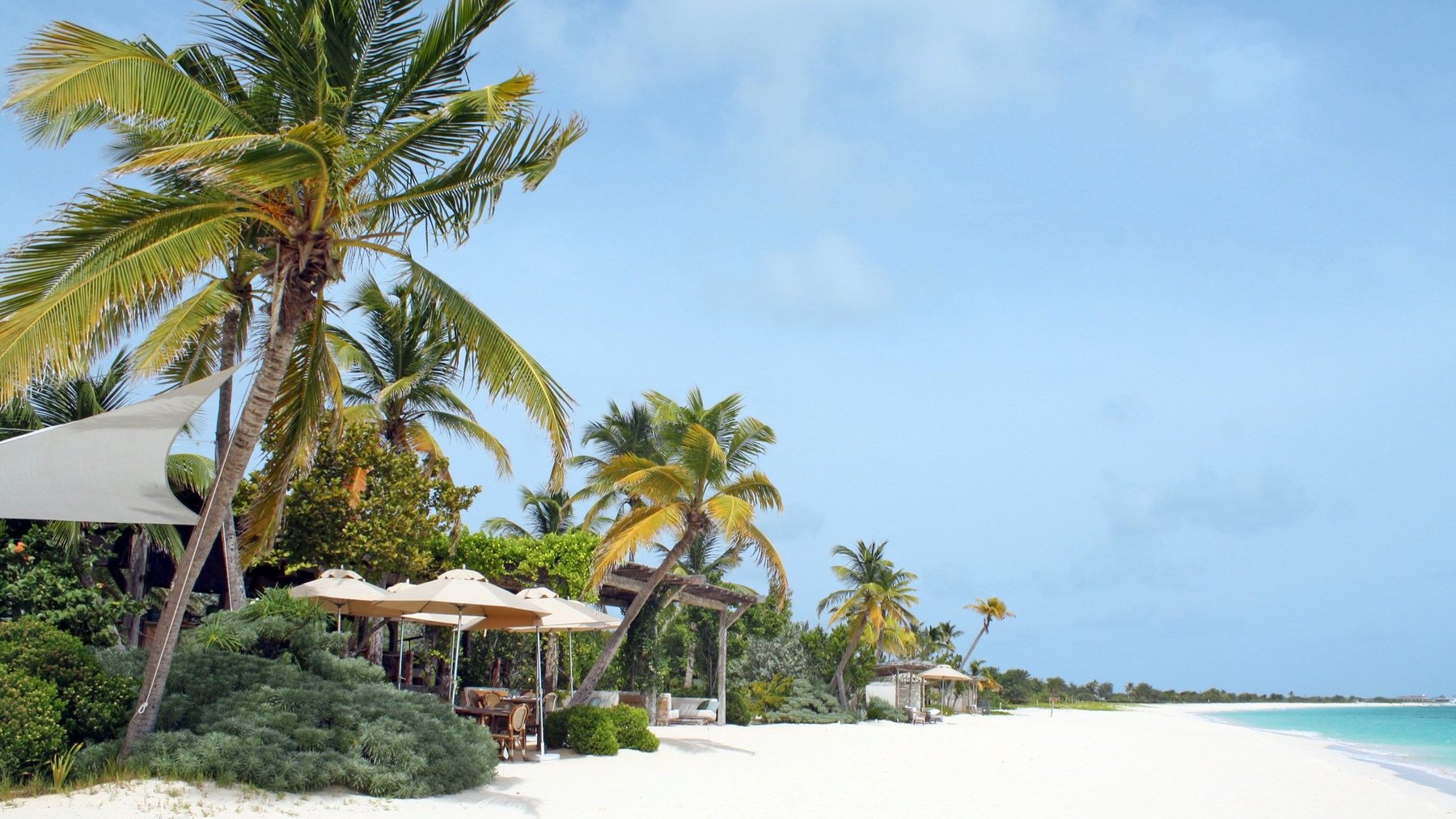Sail shades and beach dining pavilion on the white sand at Nobu Barbuda