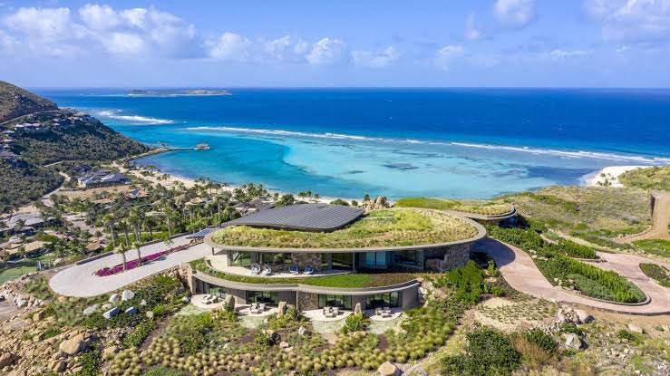 Green-roofed contemporary villa above the beach and turquoise reef at Oil Nut Bay, Virgin Gorda