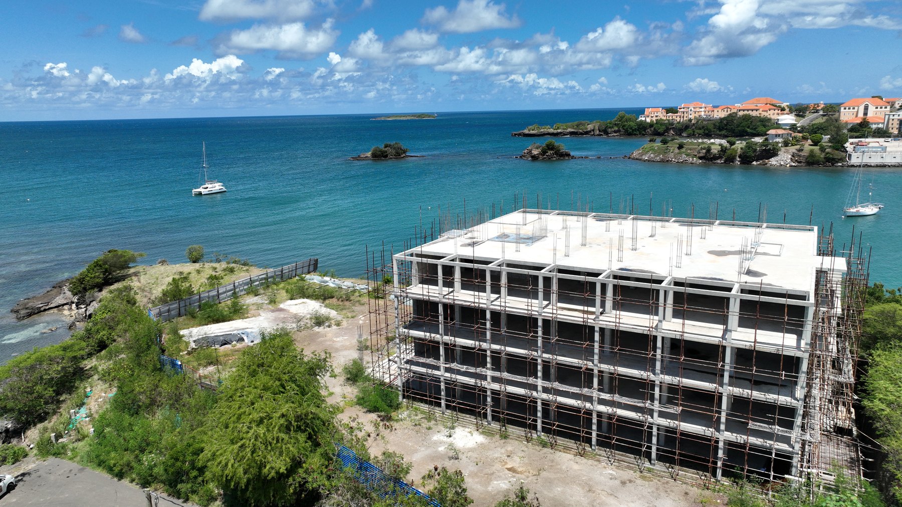 The concrete frame of One True Blue under construction above True Blue Bay, Grenada