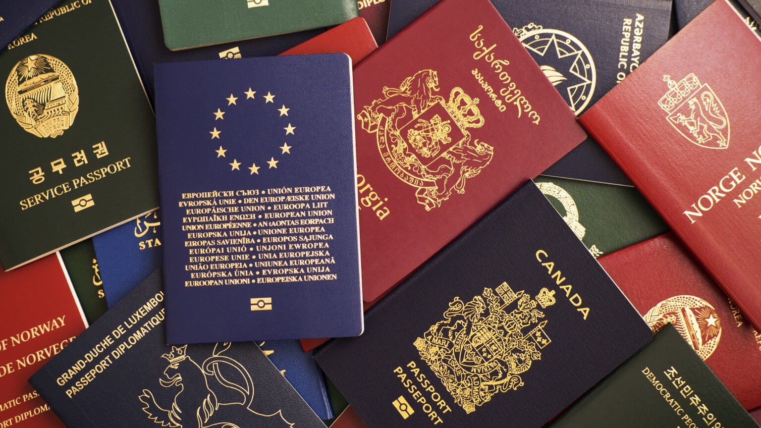 Passports from many different countries fanned out in an overlapping pile of covers