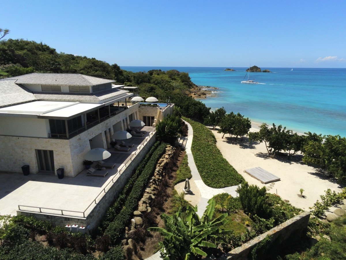 Completed coral-stone villa with shaded terraces above a turquoise beach at Pearns Point, Antigua