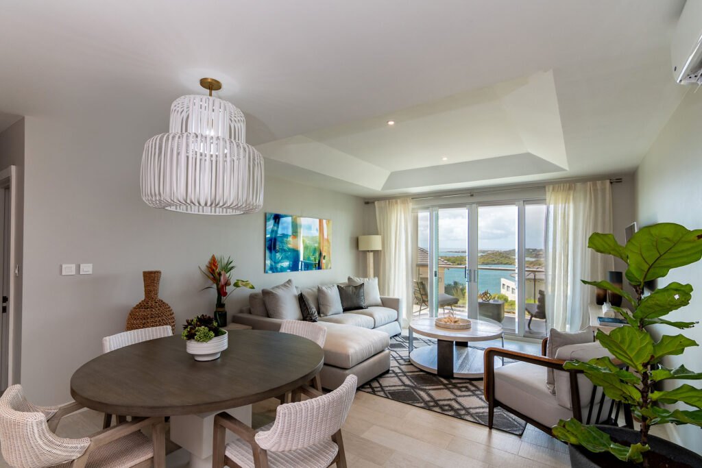 Living and dining area at The Point at Petite Calivigny, Grenada, opening onto a bay-view balcony