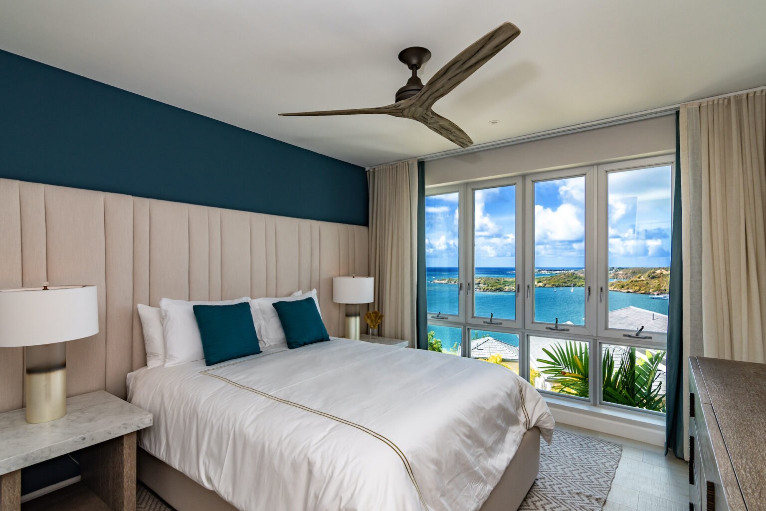 Bedroom at The Point at Petite Calivigny, Grenada, with tall windows opening to the bay