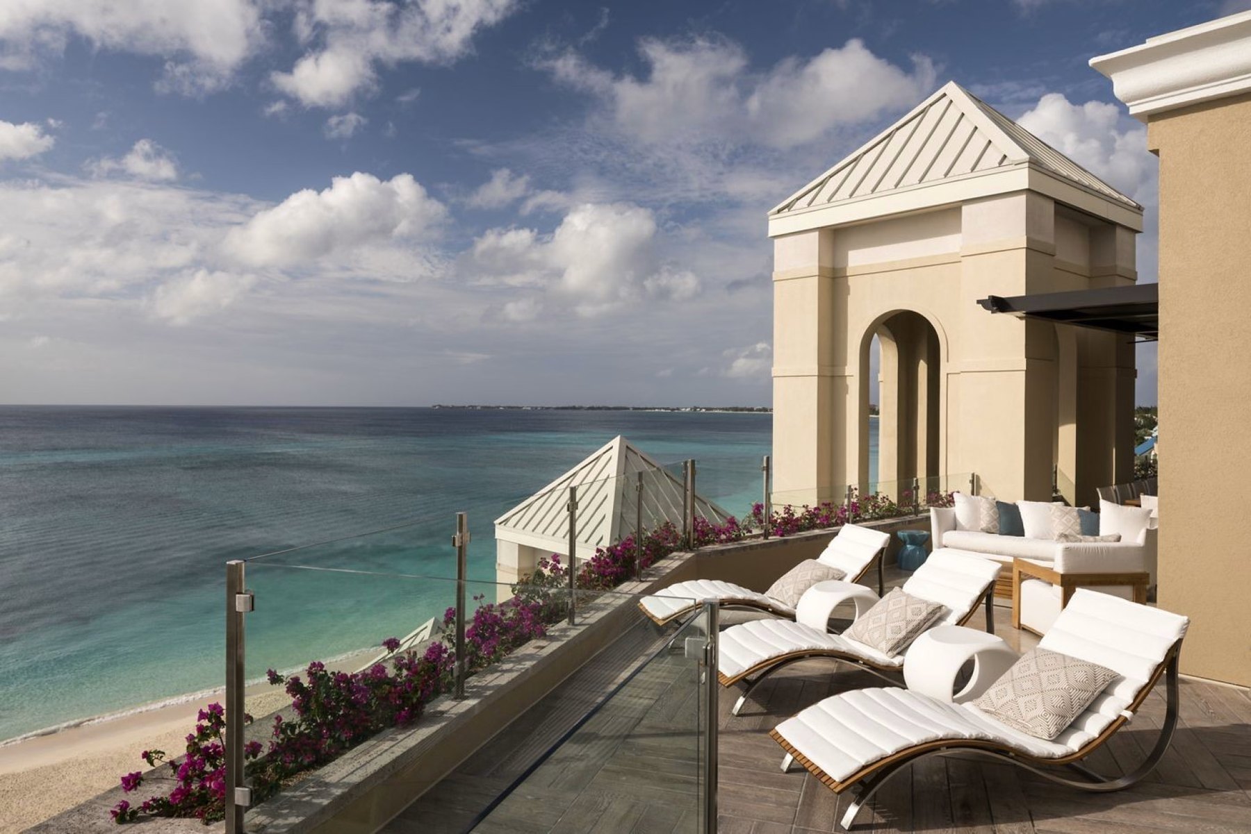 Private rooftop sun terrace with loungers and bougainvillea above Seven Mile Beach, Grand Cayman