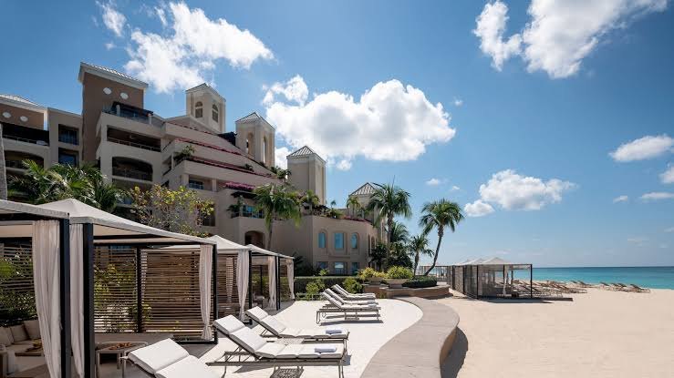 Beach cabanas and loungers below the Ritz-Carlton residence facade, Seven Mile Beach, Grand Cayman