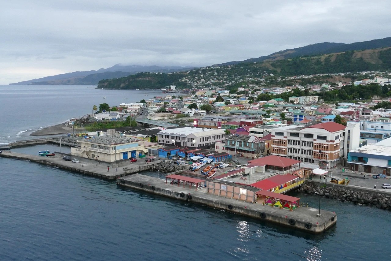 Roseau's waterfront and cruise berth on an overcast morning, the capital's commercial district rising to forested ridges behind