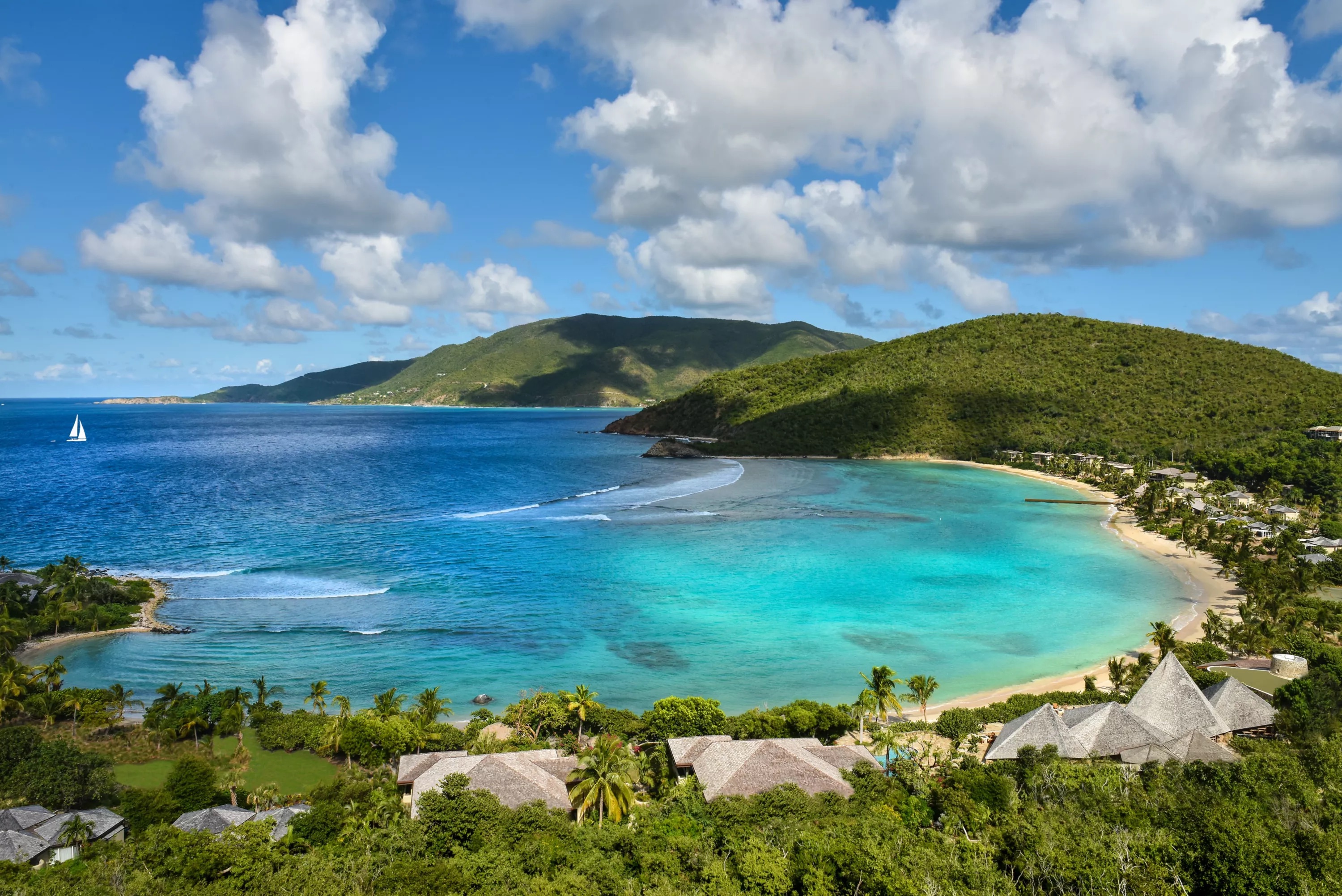 Elevated view over Little Dix Bay's turquoise crescent and shingled cottage roofs, Virgin Gorda