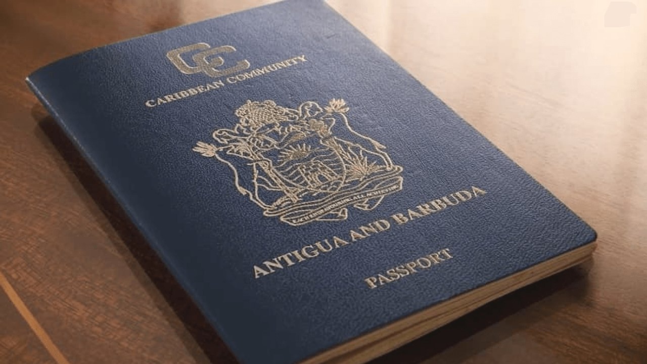 Single dark blue Caribbean Community passport lying closed on a polished wooden table