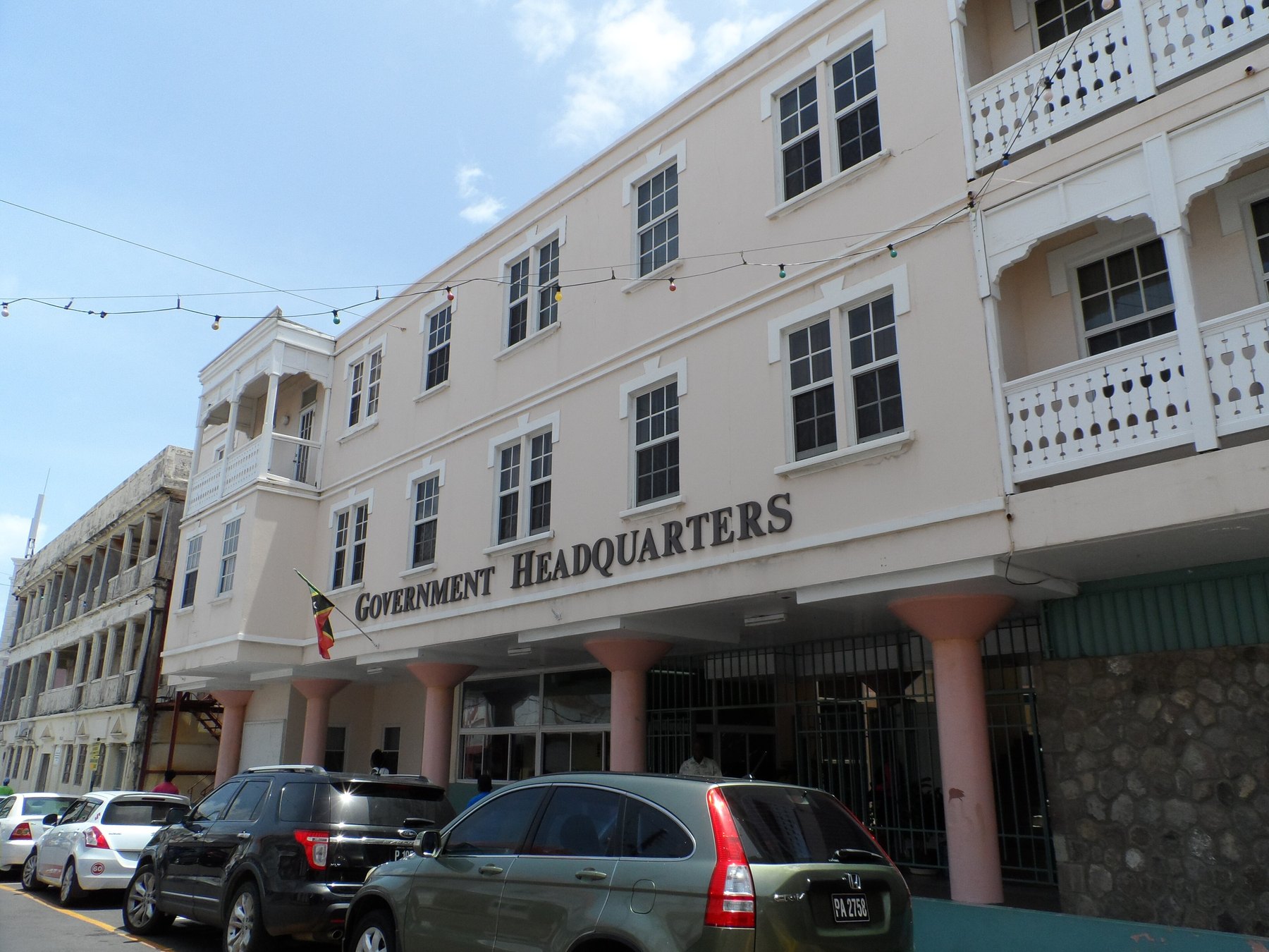 The Government Headquarters building in Basseterre, St Kitts, the national flag flying above its street colonnade