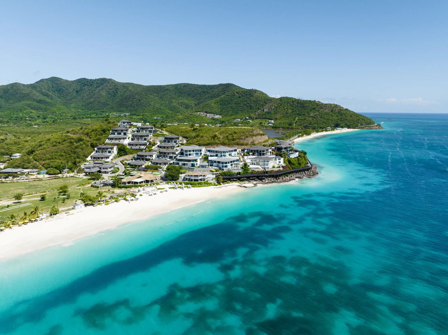 White-sand beach and green hills below the Tamarind Hills villas, Antigua's south-west coast