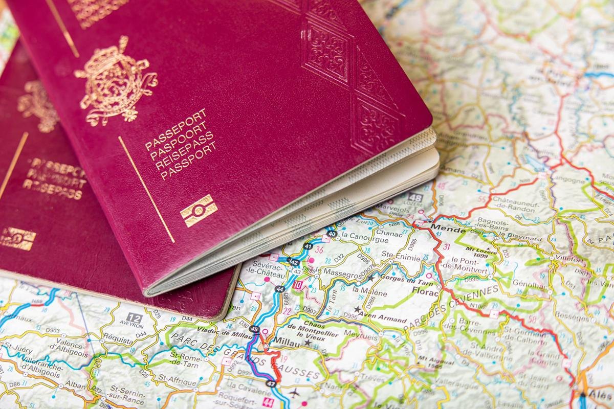 Two burgundy passports lying on a detailed road map, shallow depth of field