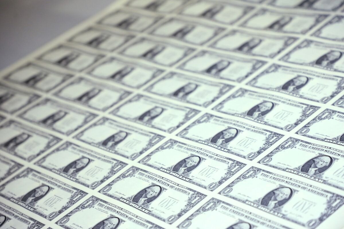 Close view of an uncut printed sheet of one-dollar banknotes in repeating rows