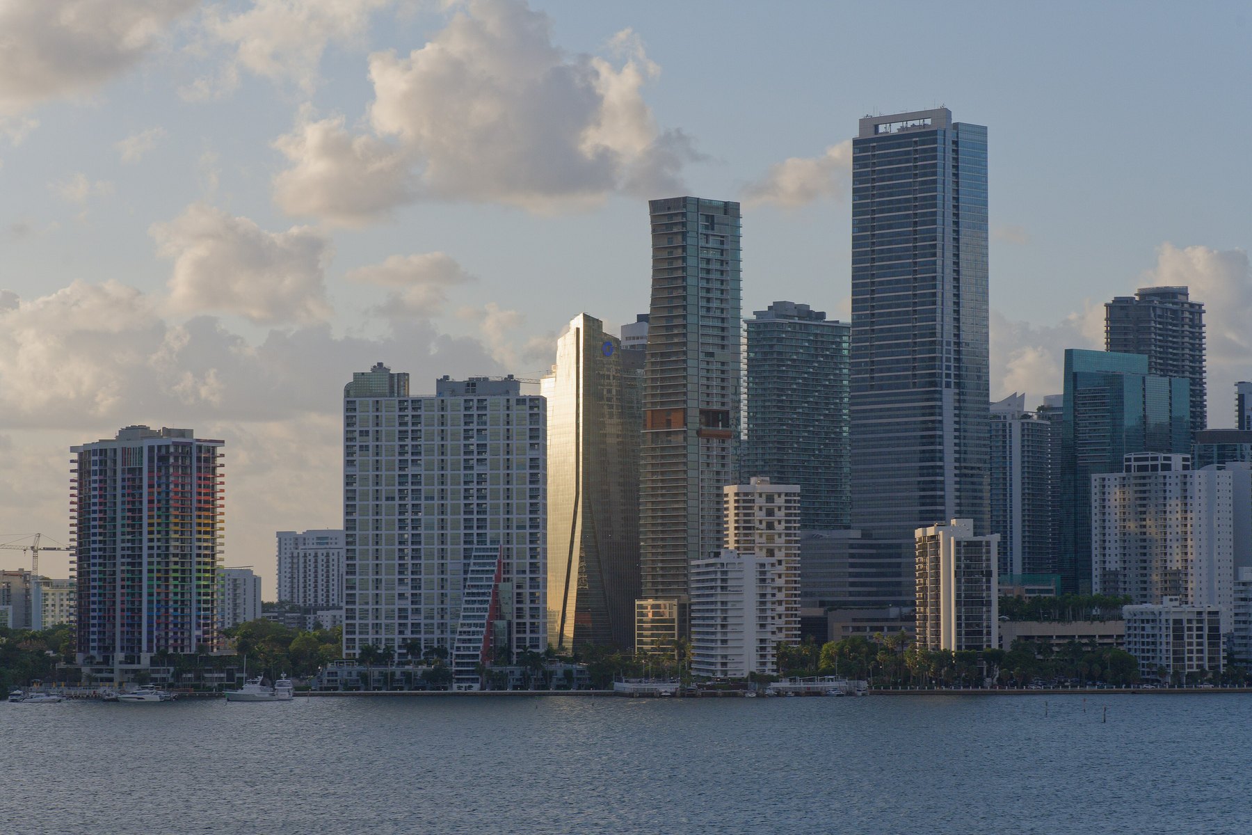 Cluster of waterfront residential and office towers in warm evening light across open water