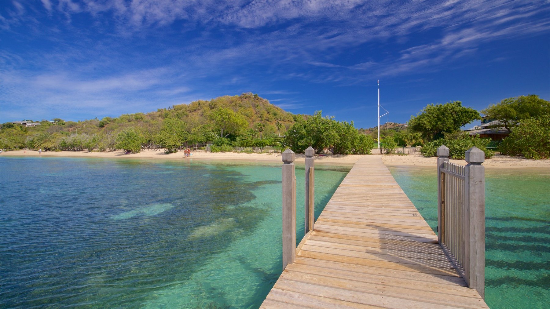 New timber jetty running out over clear shallow water toward a small sandy cove