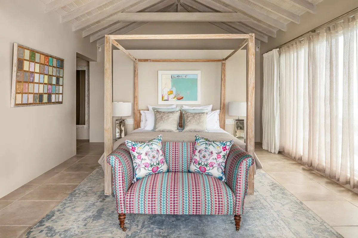 A four-poster bedroom with a striped daybed