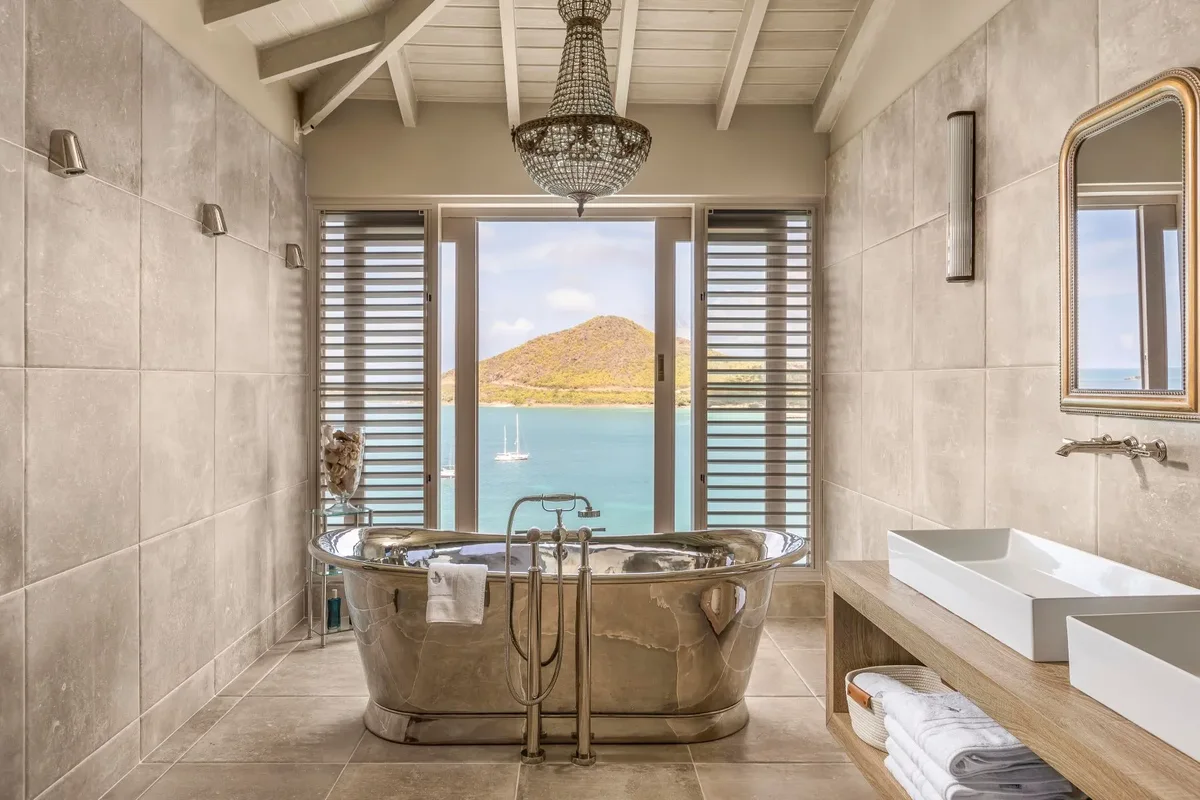 A bathroom with a roll-top tub and a sea view