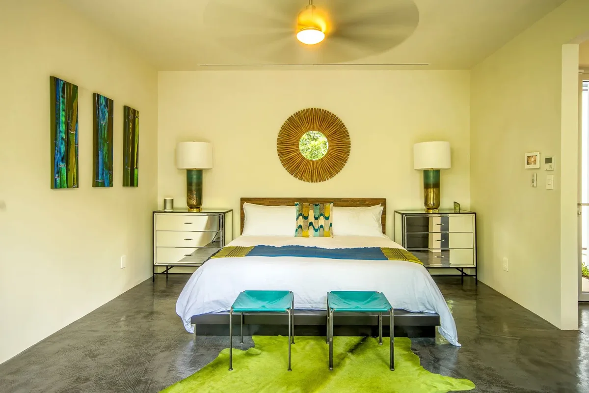A bedroom with a sunburst mirror
