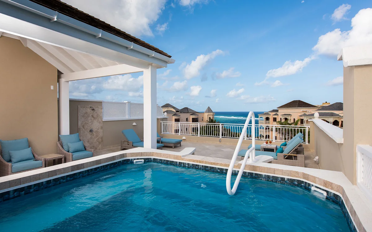 Photo of a private rooftop pool deck on a built unit: pool with handrail in the foreground, pale blue lounge