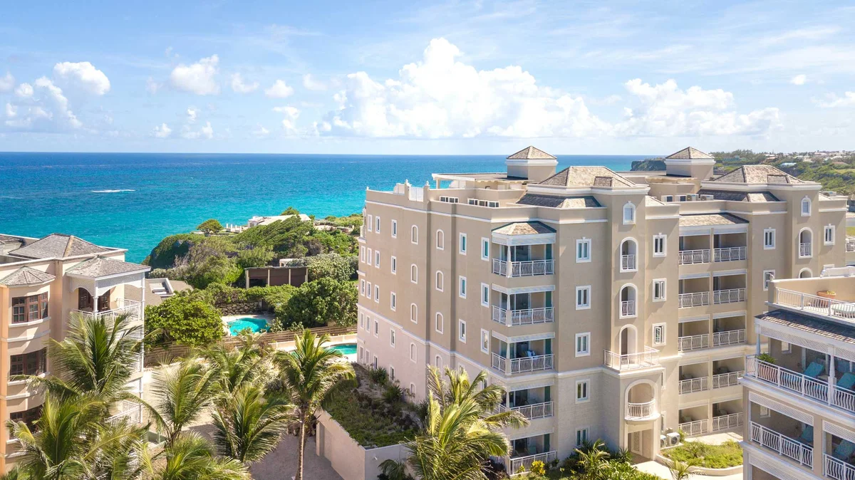 Aerial photo of a residence building exterior: five-storey coral-stone block with arched windows and white