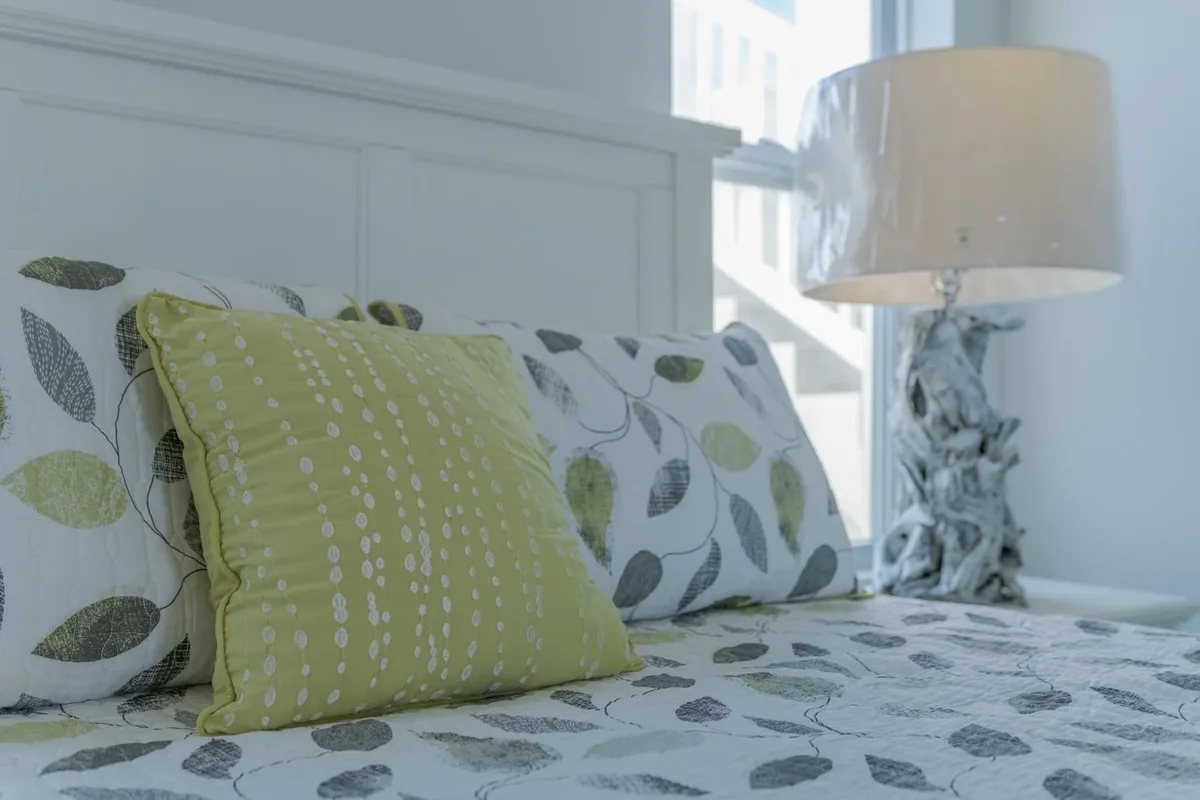 A bedroom made up with patterned cushions