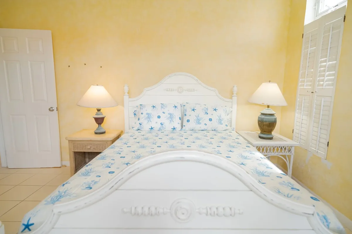 A bedroom with a carved white bedhead