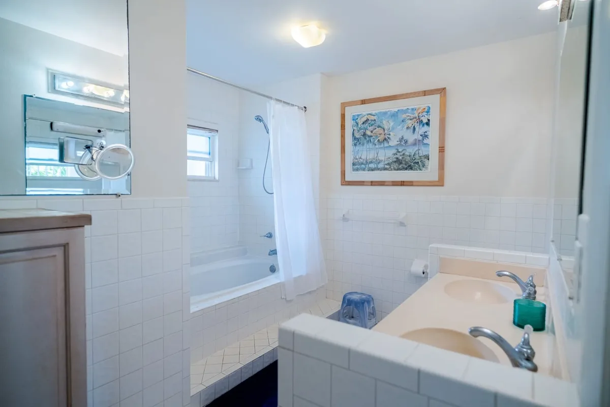 The bathroom with a tub and vanity