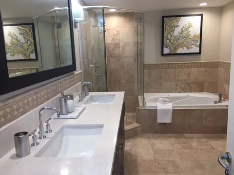 a bathroom with twin vanities and a corner tub