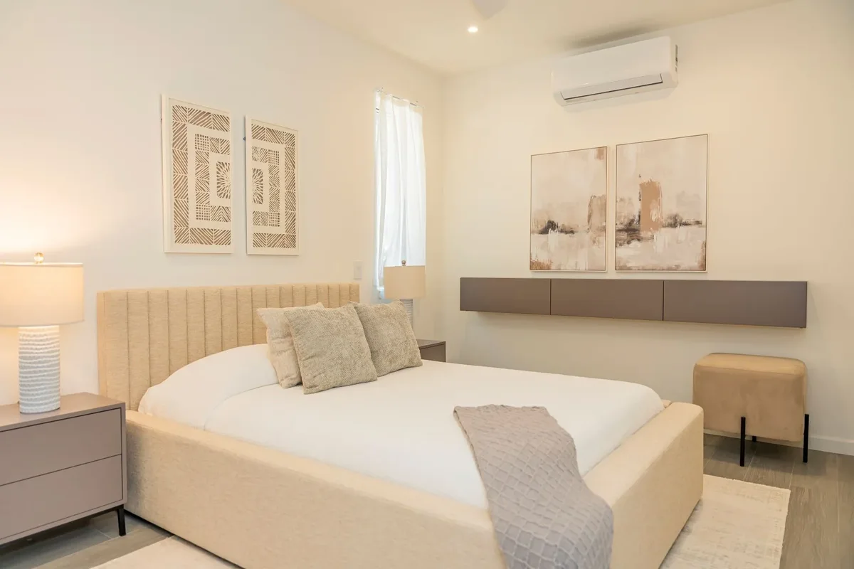 A bedroom with a bench at the foot of the bed