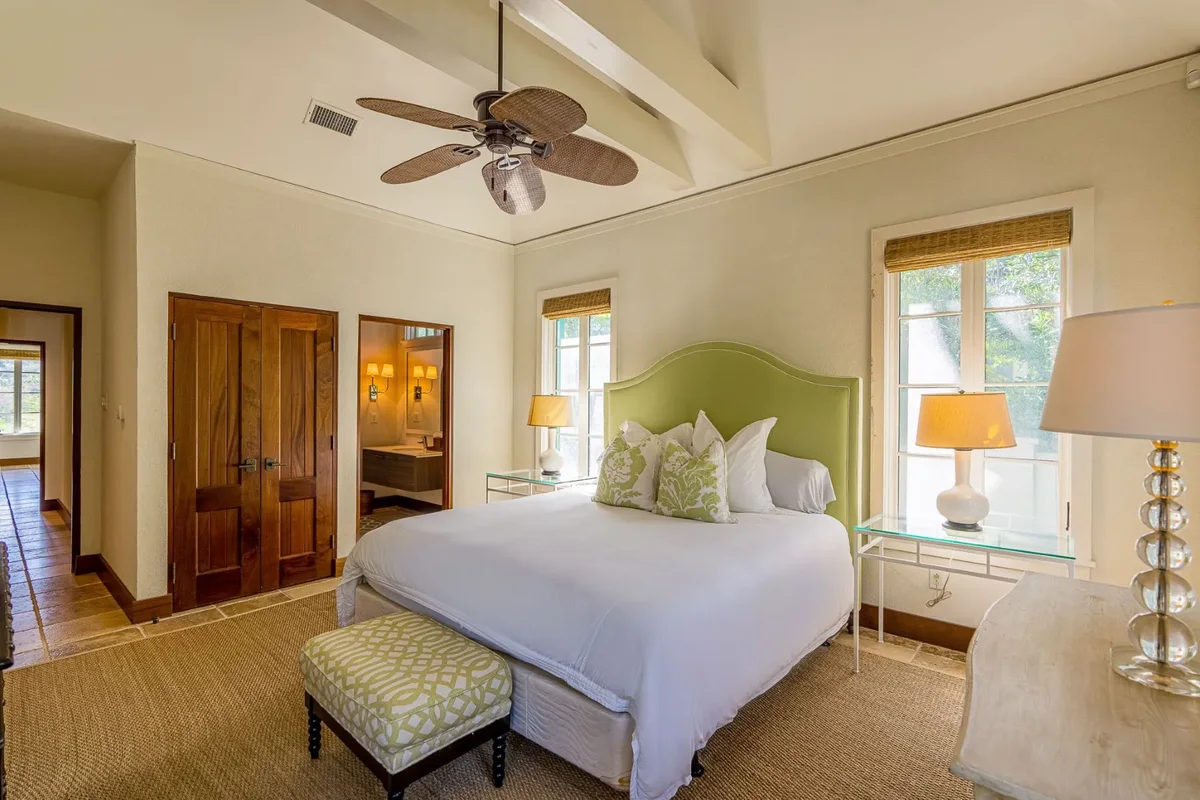 A bedroom with a green headboard