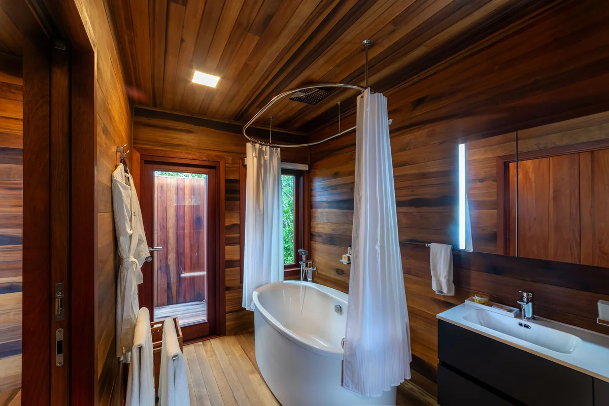 PHOTO β bathroom with freestanding soaking tub, hoop shower curtain, vanity with basin, timber walls, slot